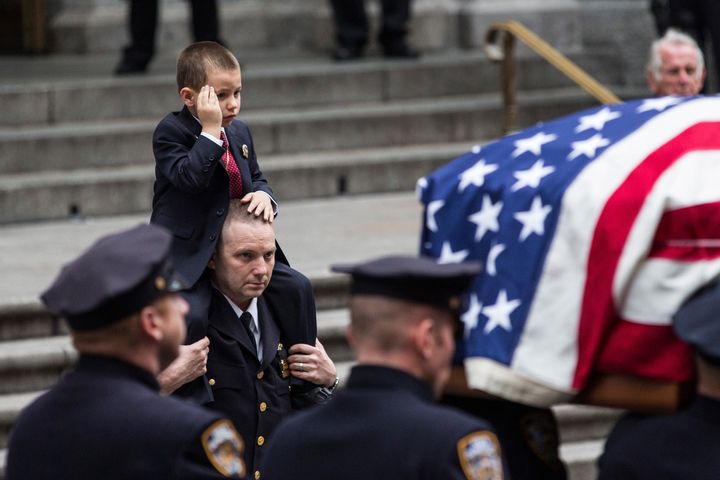 Ryan Lemm, 4, salutes as his father's casket is brought out of St. Patrick's Cathedral in New York City after the officer's funeral on Dec. 30, 2015.