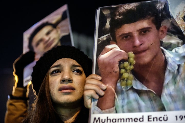 People shoot slogans as they hold pictures of victims of the Roboski strike and people who died during clashes in east Turkey, on December 28, 2015 as part of a march at the istiklal avenue in Istanbul.