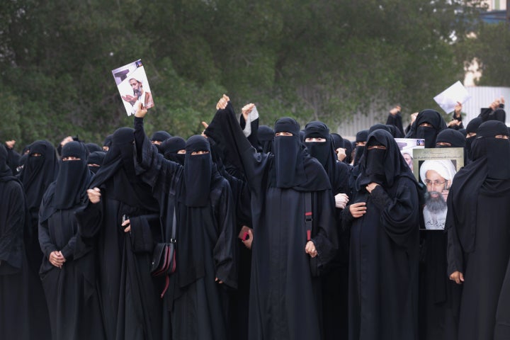 Saudi Shiite women hold placards bearing a portrait of prominent Shiite Muslim cleric Nimr al-Nimr during a protest in the eastern coastal city of Qatif against his execution by Saudi authorities, on January 2, 2016.