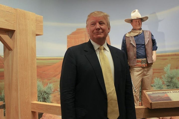 Donald Trump posing with a statue of John Wayne in the background before an event in Winterset, Iowa, on June 27, 2015.