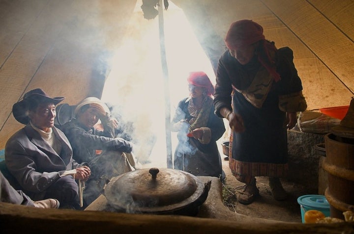 Nomads cook over a yak-dung fire in Qinghai, China.