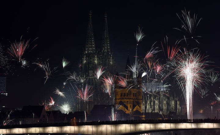 Fireworks explode over the river Rhine in front of the Great Saint Martin Church and the Cologne Cathedral during New Year's celebrations in Cologne on January 1, 2016.