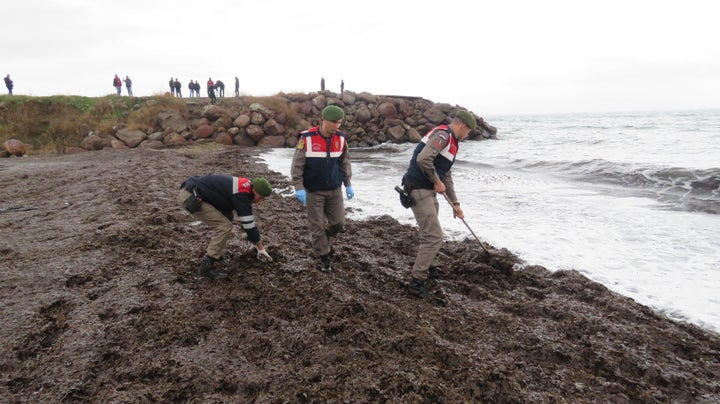 Turkish gendarmeries investigate a crime scene along the Aegean coast. At least 34 refugees and migrants drowned attempting t