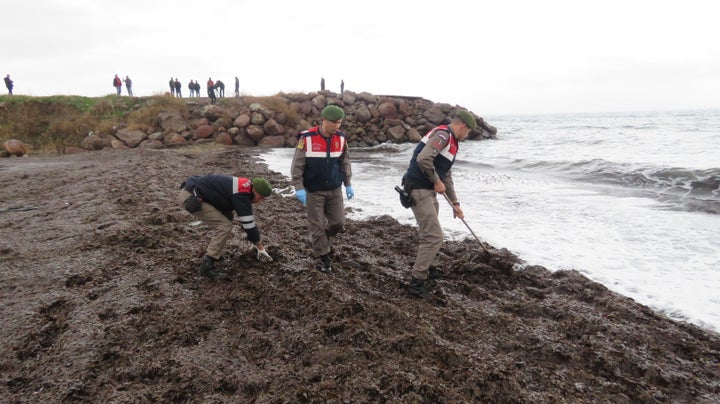 Turkish gendarmeries investigate a crime scene along the Aegean coast. At least 34 refugees and migrants drowned attempting to cross to Greece.