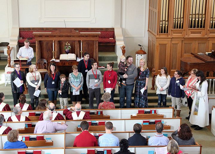 Pastor Robin Bartlett, far right, conducts a new-member ceremony at First Church in Sterling, Mass.