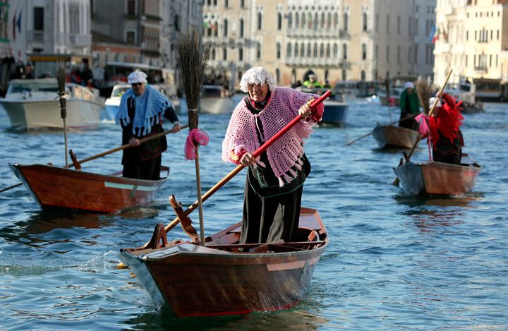 Men dressed as “La Befana,” an imaginary old woman who is thought to bring gifts to children during the festival of Epiphany, row boats down the Grand Canal in Venice on Jan. 6, 2012.