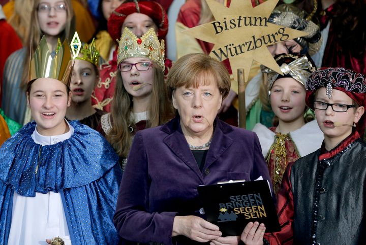 German chancellor Angela Merkel, center, sings with carolers during a reception for carol singers from all over Germany at the chancellery in Berlin, Germany, Tuesday, Jan. 5, 2016.