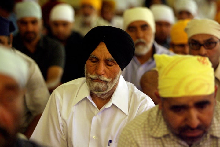 Sikh men pray at the Sikh Temple of the Frenso Sikh Society on in Fresno, California. The city's first homicide victim in 2016 is a Sikh, sparking fears of rising prejudice.