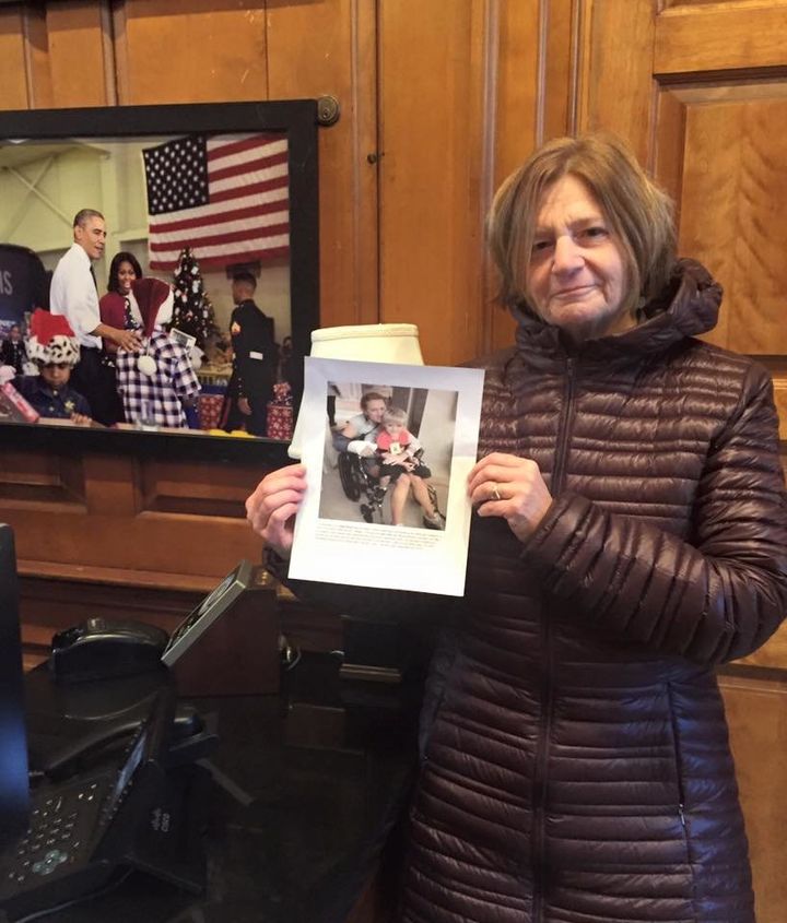 Clai Lasher-Sommers, pictured at the White House, holds up the photo of another domestic violence shooting survivor, Kate Ranta. 