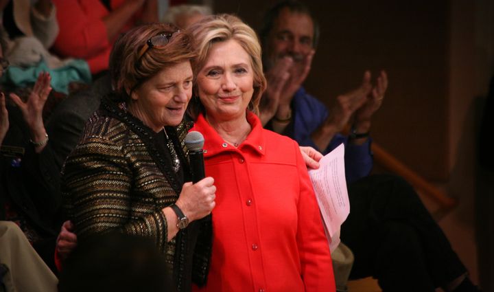 Democratic presidential candidate Hillary Clinton puts her arm around a gun violence survivor during a campaign event in New Hampshire. Clinton's proposed executive action on background checks put pressure on Obama to act.