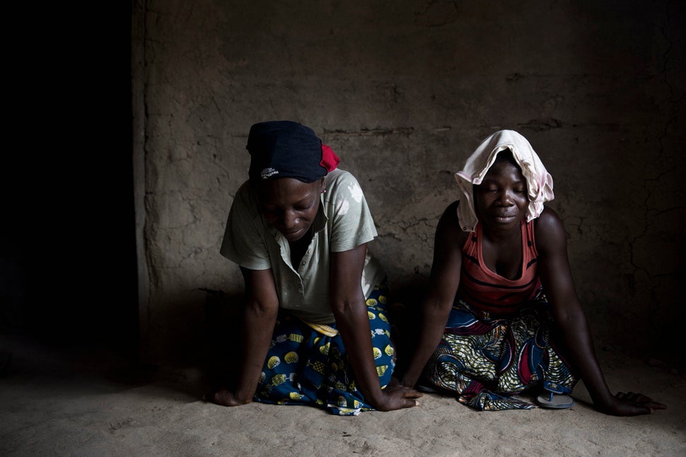 Women pray for the many individuals who never came back from the bush, where they were sent with a bucket of homemade me