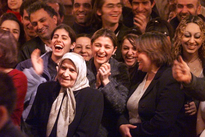 A large crowd reacts to dance contest at an Iranian Bazaar in honor of the Baha'i New Year, Naw-Ruz.