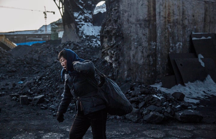 A Chinese woman collects coal in a sorting area at a coal mine on Nov. 25, 2015, in Shanxi, China.&nbsp;Some have speculated 