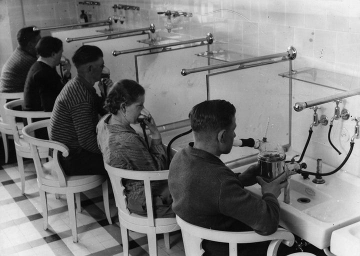 Patients at a hospital in Germany inhaling powdered medicines such as menthol and eucalyptus to heal respiratory diseases, circa 1930.