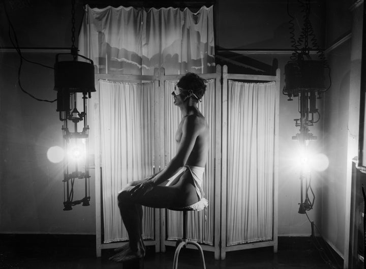 A man enjoys a sun-ray lamp, circa 1930.