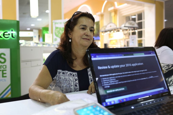 Martha Lucia sits with an insurance agent as she picks a health plan at the Mall of the Americas in Miami on Nov. 2, 2015.