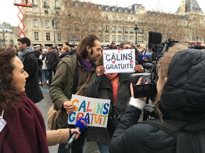 A man and a woman offer free hugs to the people of Paris.