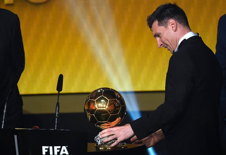 Lionel Messi curiously looks at a familiar sight: Another FIFA World Player of the Year award. 