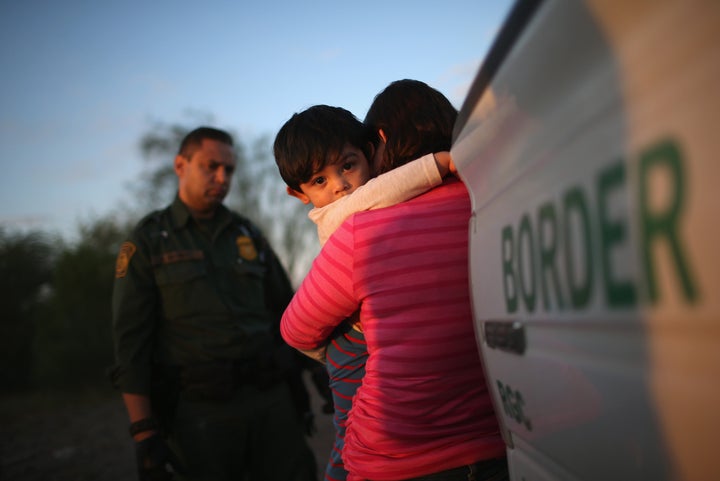 A 1-year-old from El Salvador clings to his mother after she turned themselves in to Border Patrol agents on Dec. 7, 2015, near Rio Grande City, Texas.