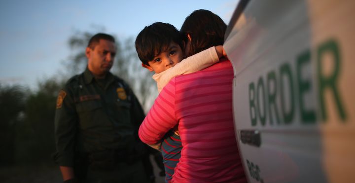 A 1-year-old from El Salvador clings to his mother after she turned them in to Border Patrol agents near Rio Grande City, Texas, in December.