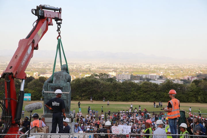 Students celebrate as the Cecil John Rhodes statue is removed at the University of Cape Town on April 9, 2015 in CapeTown, South Africa. After nearly a month of protesting, sit-ins and relentless meetings by students, the statue of British colonialist will finally be removed. 