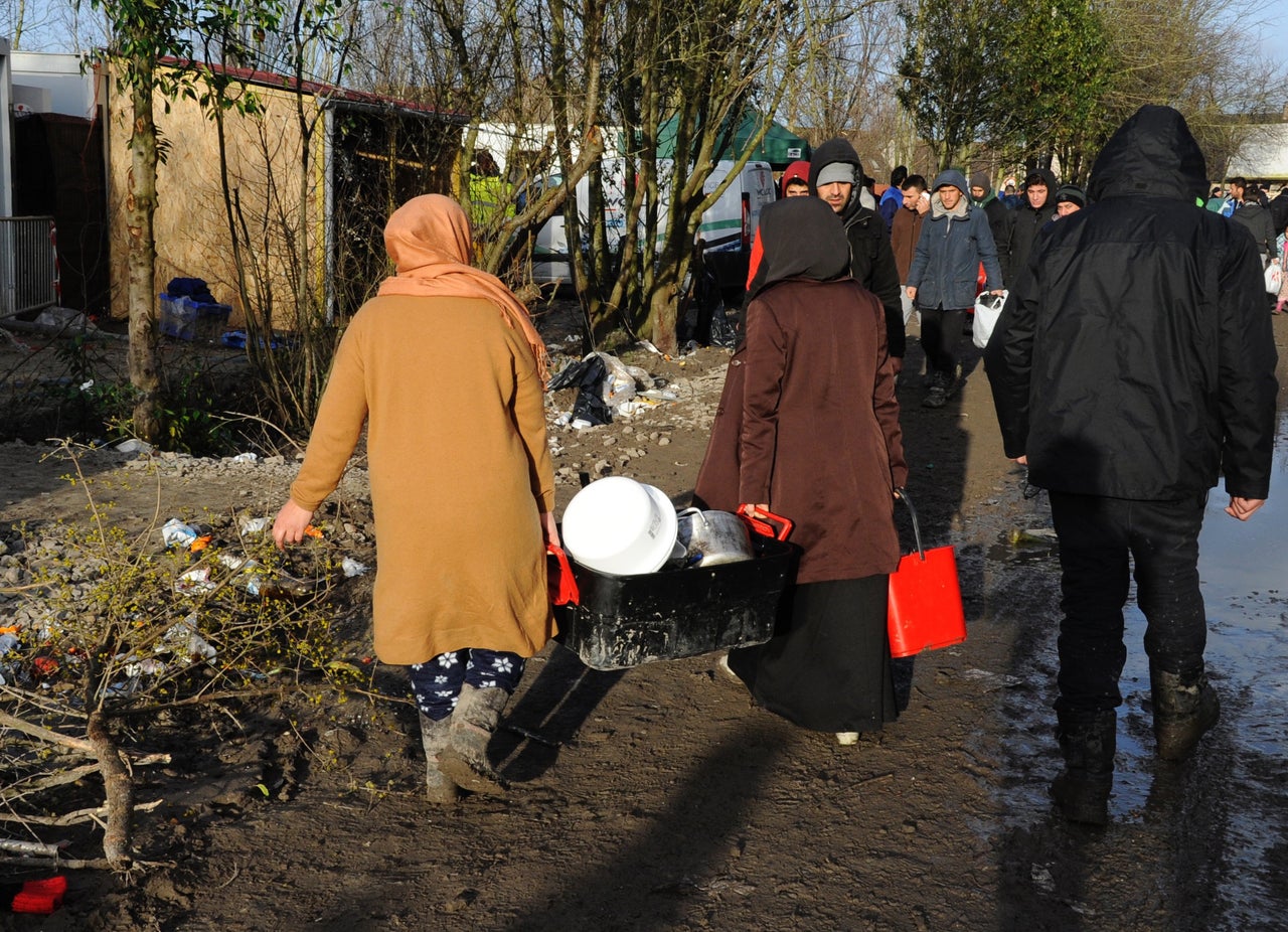 Women carry pots and pans towards the spigot. Sometimes their only respite is drinking a cup of tea.