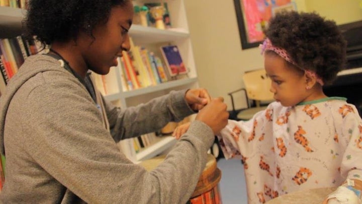 A dancer wraps around the arm of a patient a bracelet they made together.