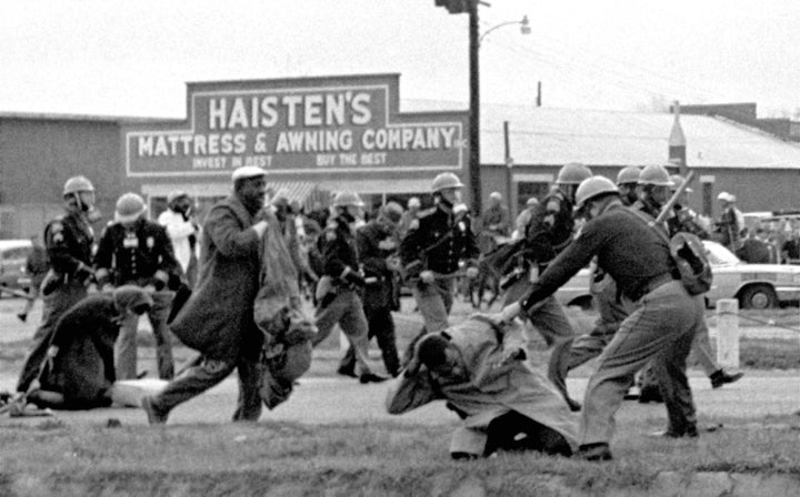 In this March 7, 1965, photo, state troopers use clubs against participants in a civil rights march in Selma, Alabama. At the foreground right, John Lewis, then head of the Student Nonviolent Coordinating Committee, is beaten by a state trooper.