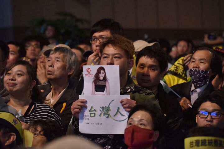 Taiwanese pop star Chou Tzuyu has apologized after being accused of inadvertently supporting Taiwanese sovereignty shortly before the island's presidential election. Here, a supporter of Taiwan's pro-independence Democratic Progressive Party holds Chou's photo.