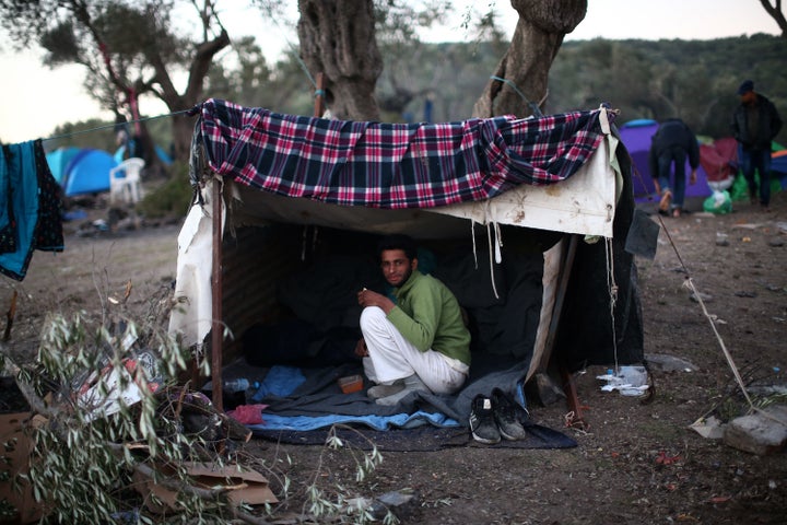 A migrant from Pakistan sits in his makeshift tent on Lesbos, Greece, on Nov. 16, 2015. After arriving on the island, many pe