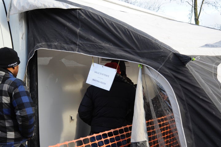 Refugees wait for medical consultations outside a makeshift medical clinic at the camp.