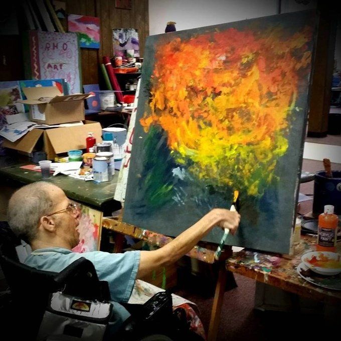 A man works on an oil painting during a Resources for Human Development workshop for people with disabilities in Pawtucket, Rhode Island.
