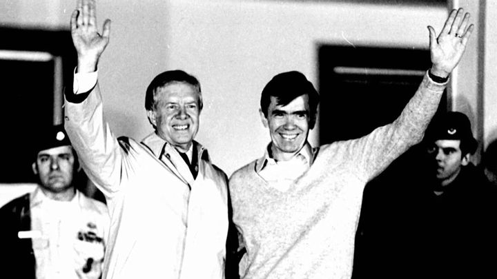 Jimmy Carter waves alongside former Iranian hostage Bruce Laingen, one day after Carter left office and the hostages were released.