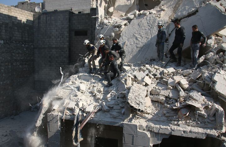 Syrians try to rescue people who are trapped under the rubble of a collapsed building after Russian airstrikes hit opposition-controlled neighborhoods in Aleppo.