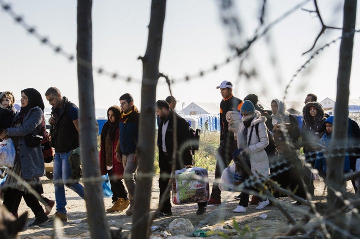 People walk across the border from Greece into Macedonia. The migrant and refugee crisis is causing EU member states to