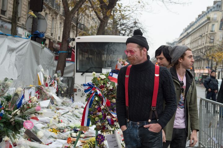 Eagles of Death Metal frontman Jesse Hughes, guitarist Matt McJunkins and drummer Julian Dorio visit a memorial that pays homage to the victims of the terrorist attacks at Le Bataclan.
