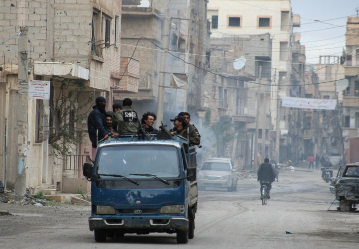 Syrian rebel groups drive through the eastern Syrian town of Deir Ezzor in 2014. Now, residents in the government-controlled areas of the town are caught in a "double blockade" between government and the self-described Islamic State, Syria Deeply reported.