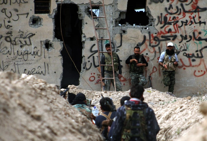 Fighters walk along a trench in Deir Ezzor. The Islamic State group blocks food from entering the town's neighborhoods, according to human rights organization Justice for Life Observatory in Deir Ezzor.