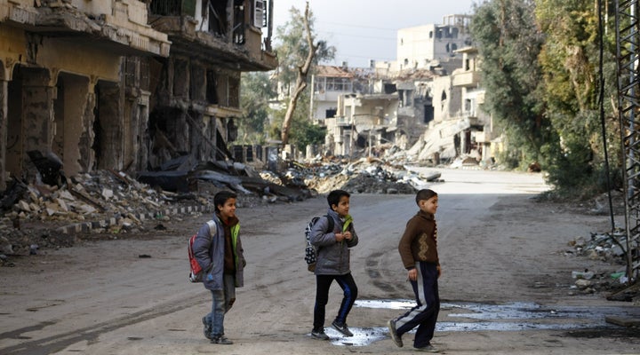 Syrian children walk to school in Deir Ezzor in 2014. The "double siege" on government-controlled parts of the