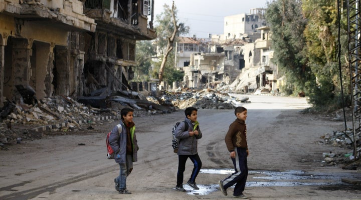 Syrian children walk to school in Deir Ezzor in 2014. The "double siege" on government-controlled parts of the province has devastated the local economy, according to Syria Deeply.