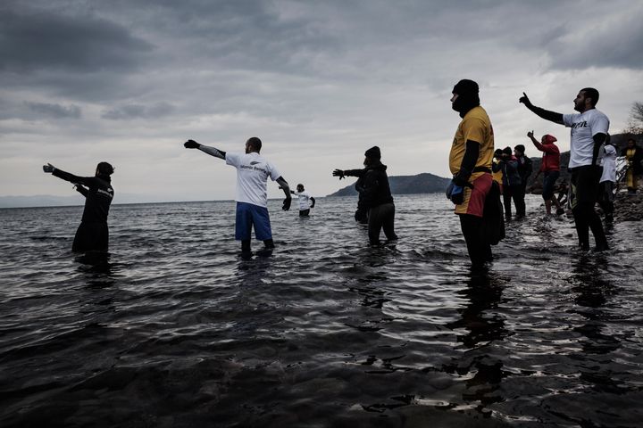 At least 42 people drowned after their boats capsized off Greek islands on Friday. Volunteers signal to an incoming rubber boat crowded with migrants and refugees near Skala Sikaminias, Greece, on Jan. 3.
