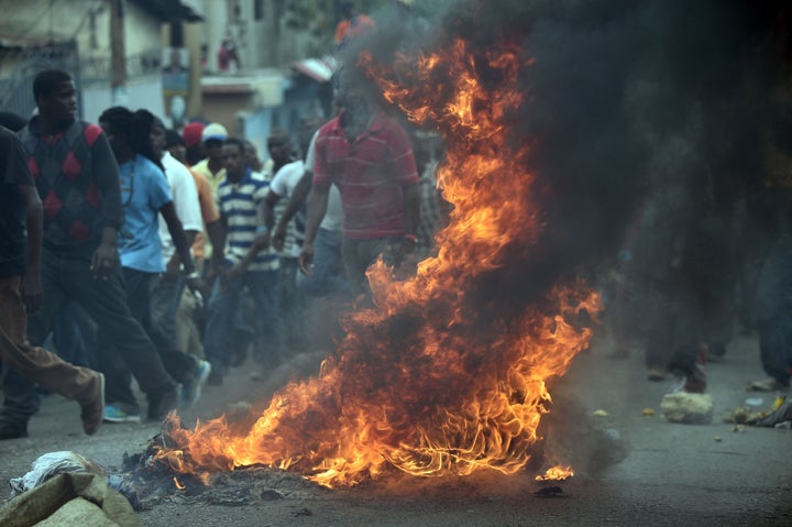 Demonstrators burn tires during a protest in Port-au-Prince, on January 22, 2016.