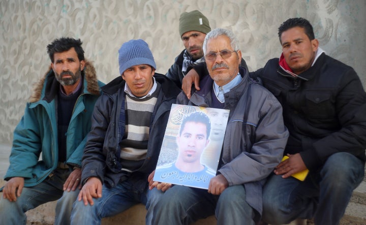 Othman Yahyaoui (C) poses with family members holding a portrait of his son, Ridha Yahyaoui, for a photo in Kasserine on Thursday. He blamed his son's death on corruption and marginalization.