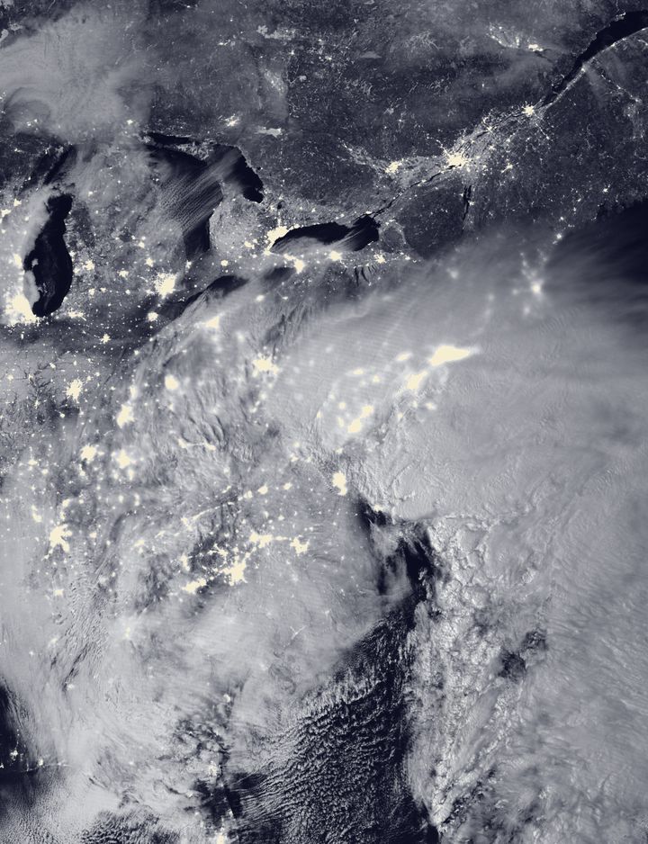 Two low-pressure systems are seen merging over the East Coast around 2 a.m. Saturday in this satellite image.