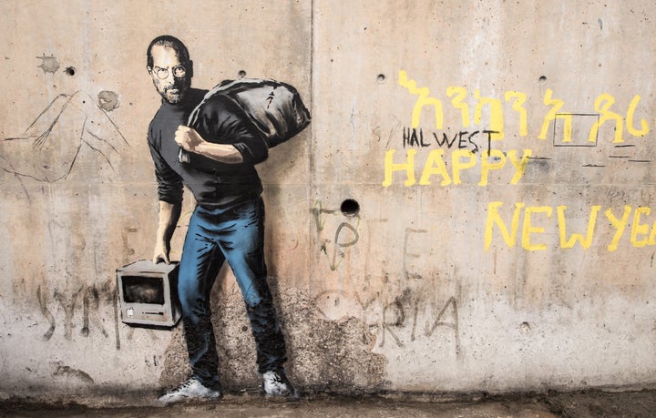 This picture taken on Dec. 12, 2015 shows a street art graffiti representing Steve Jobs, founder and late CEO of Apple, by elusive British artist Banksy at the migrant camp known as 'the Jungle' in Calais, northern France.