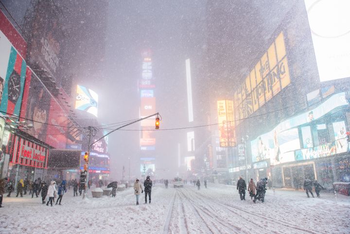 People walk in Times Square during Winter Storm Jonas on January 23, 2016 in New York City.