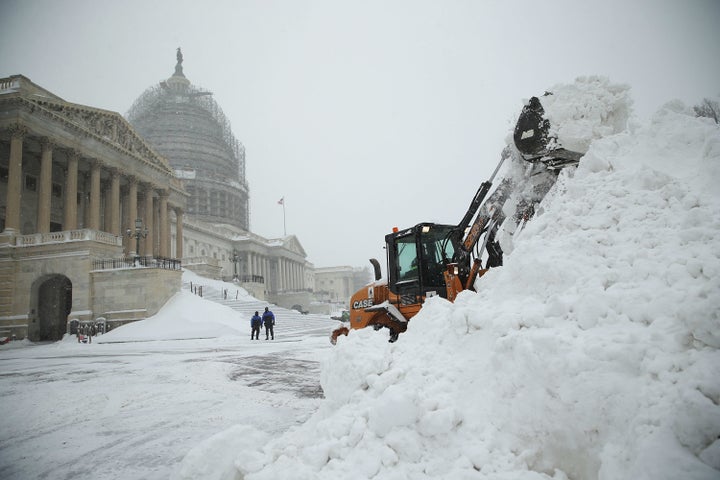 A bulldozer clears snow on the East Front of the U.S. Capitol on Jan. 23, 2016, in Washington.