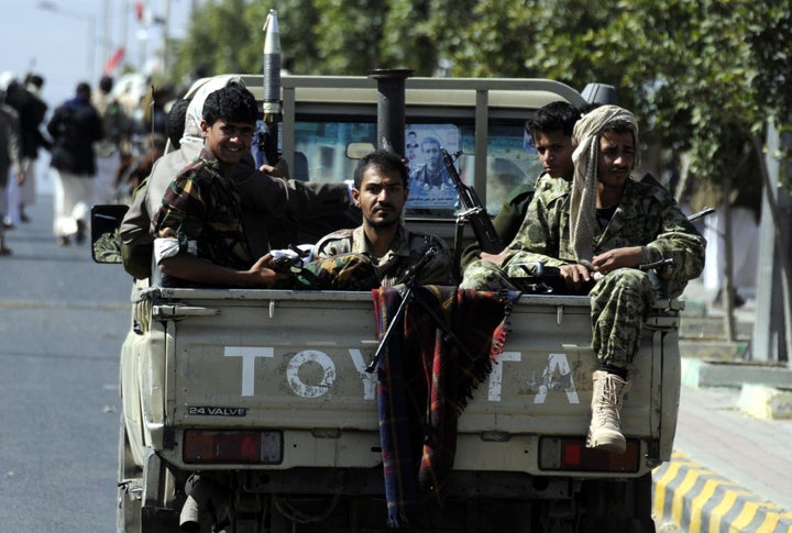 A Saudi Arabian coalition is at war with Yemen's Houthi militia. Above, armed members of the Houthi militia sit on a tru