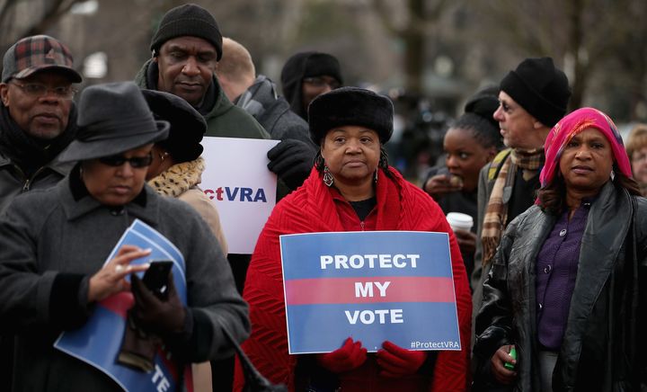 Demonstrators stand outside the U.S. Supreme Court in February 2013 as it hears arguments in the historic Shelby County v. Holder case.