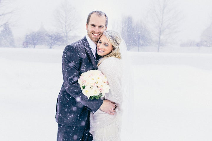 The bride and groom sharing a sweet, snowy embrace. 